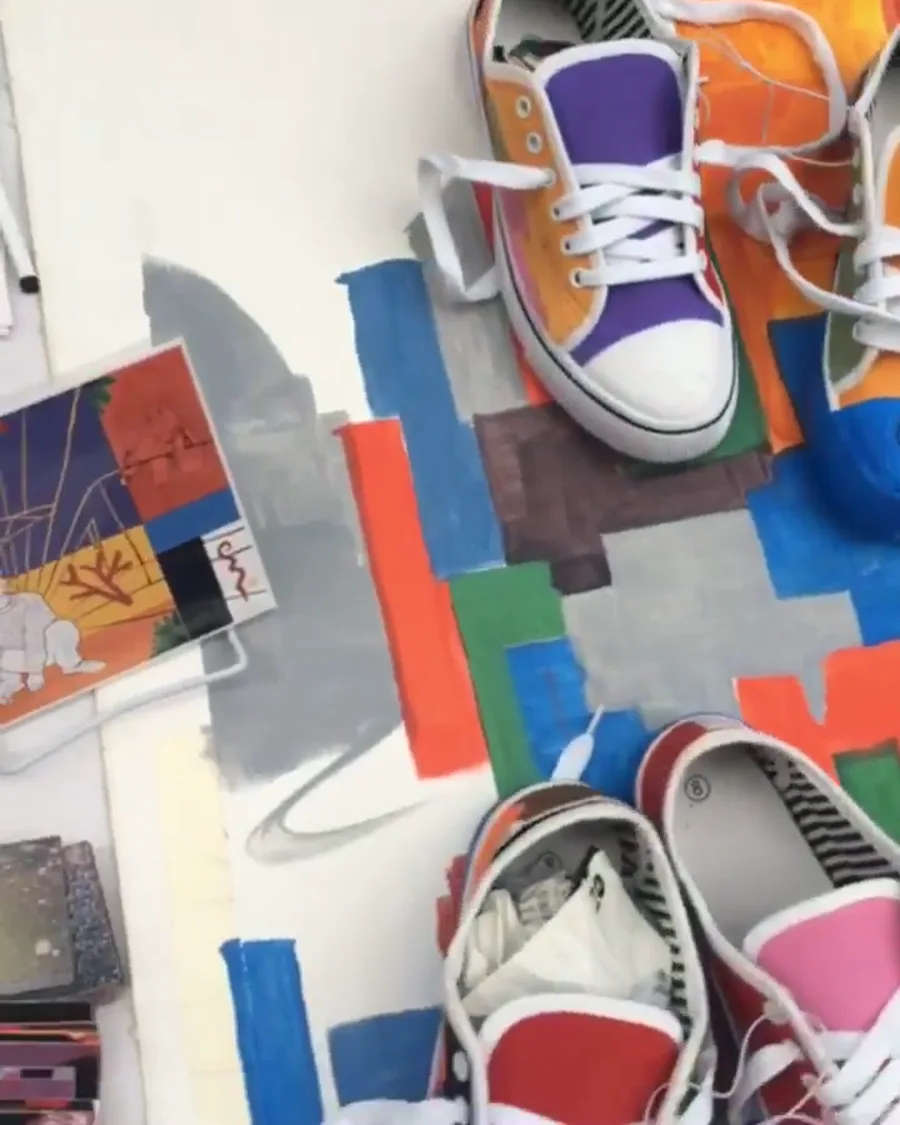Sneakers pintadas a mano junto a la obra