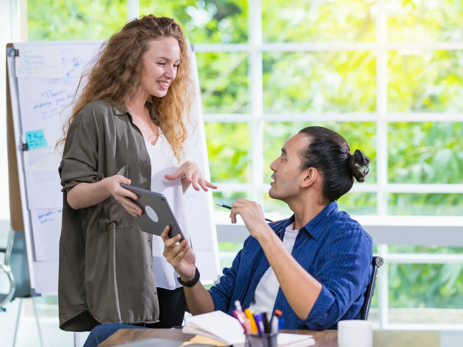 A designer showing a client the proposed design on a tablet
